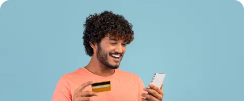 happy-indian-guy-holding-cell-phone-credit-card 1